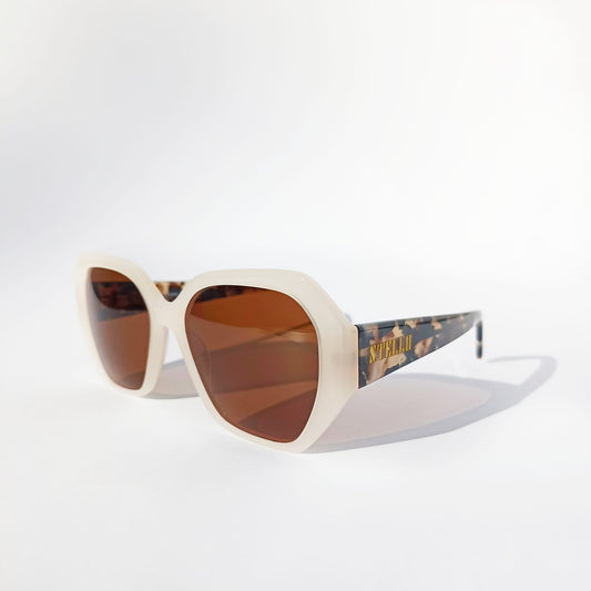 Montura de acetato colo crema del modelo Soraya con diseño ligero y lentes polarizadas marron oscuro.